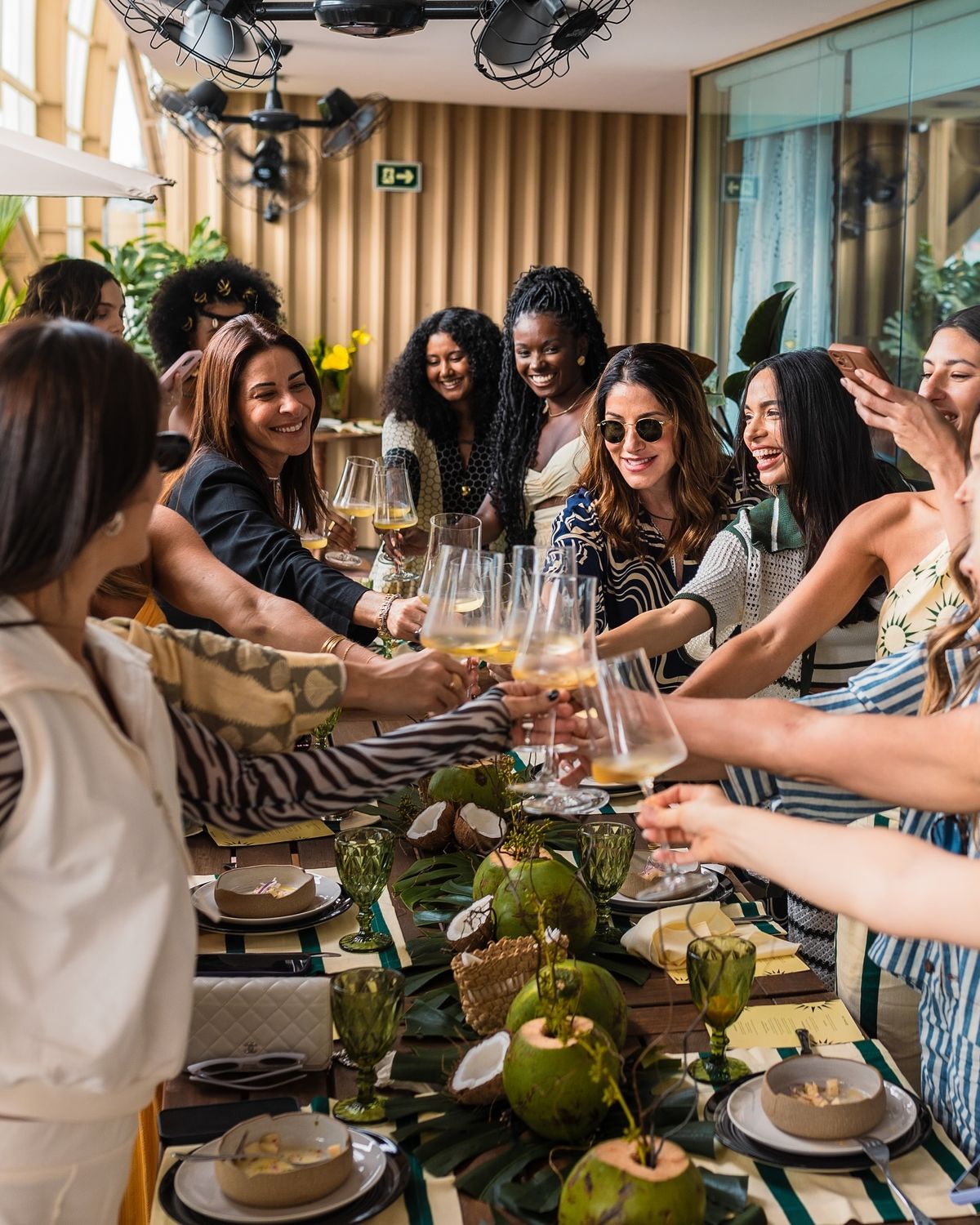 Celebração entre convidados em evento com cocos na mesa